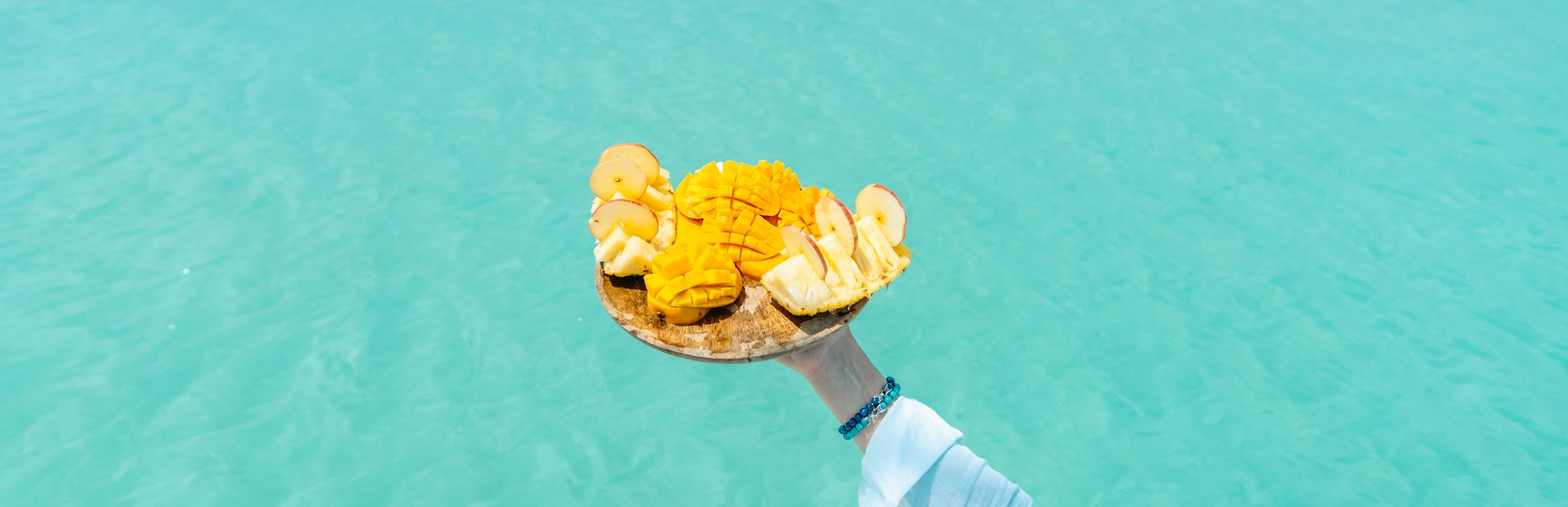 Fruta fresca servida sobre el agua turquesa de la laguna